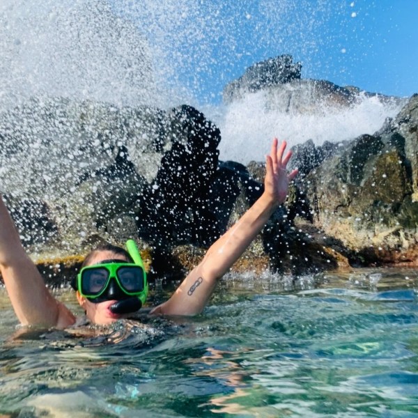 a young girl riding a wave on a surfboard in the water