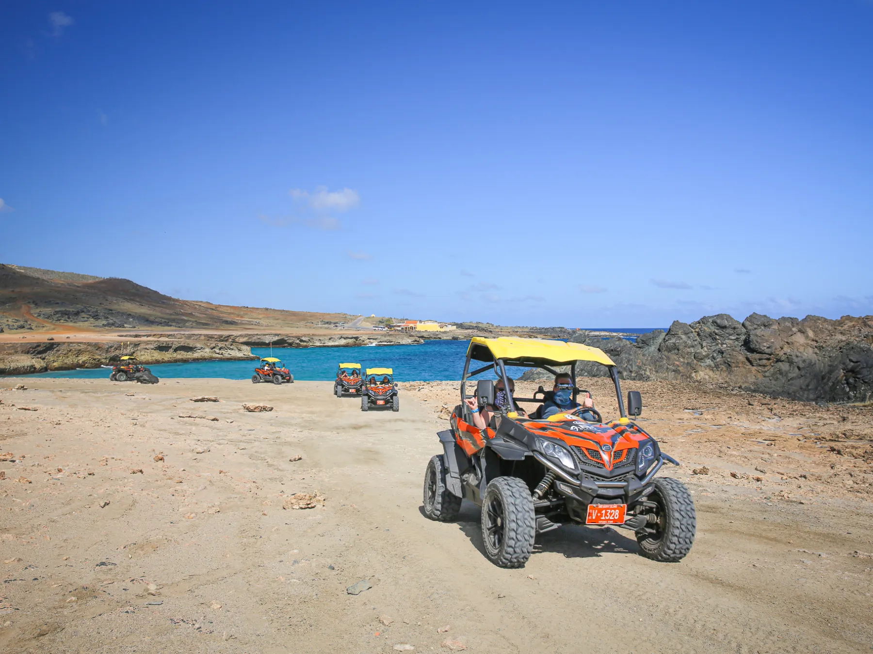 a man riding a motorcycle down a dirt road