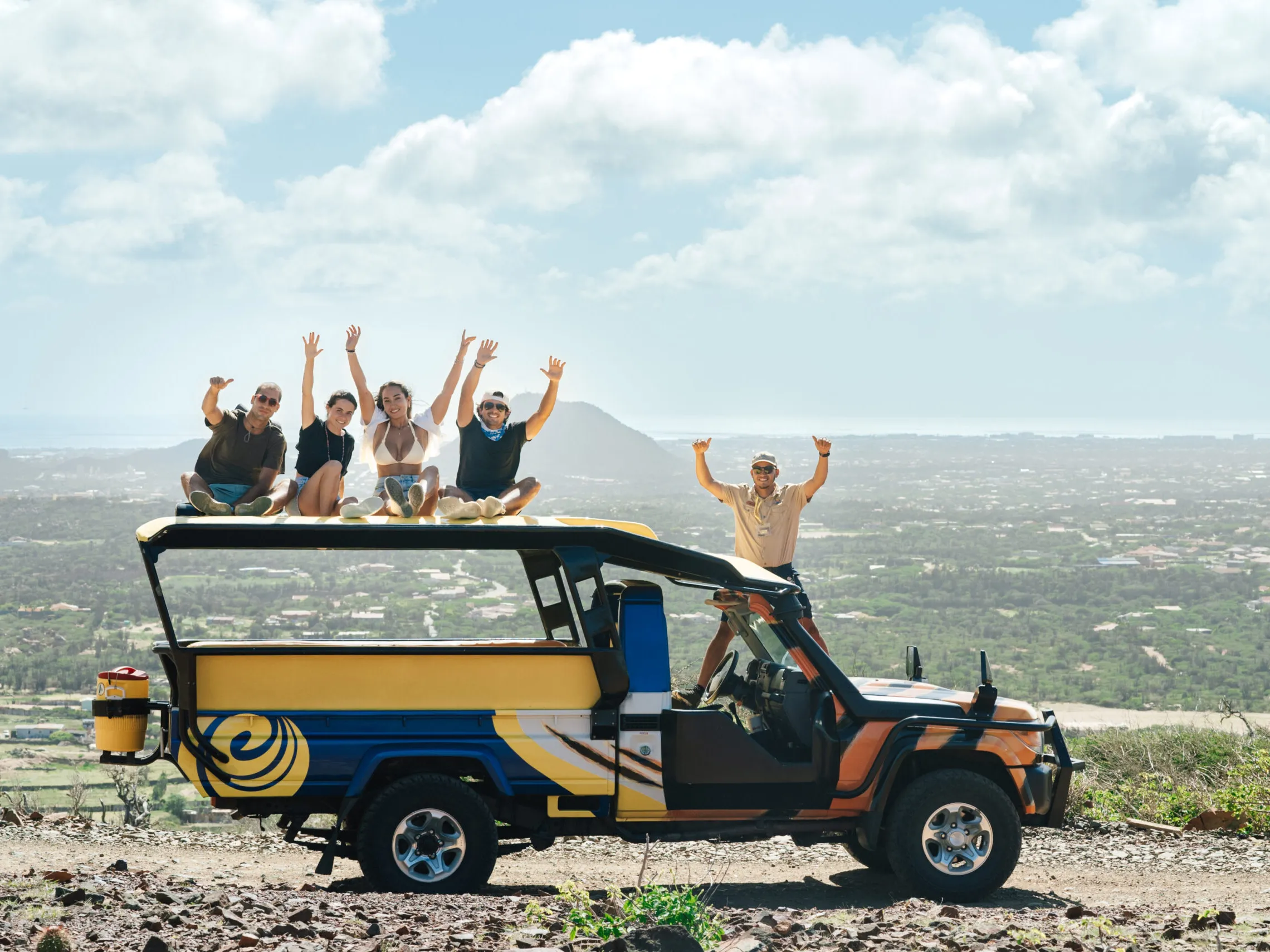 a group of people on a beach in front of a car