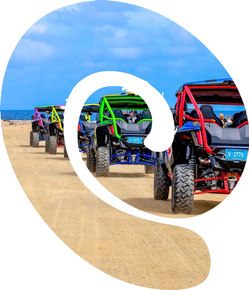 Several colorful off-road vehicles driving on a sandy terrain under a blue sky.