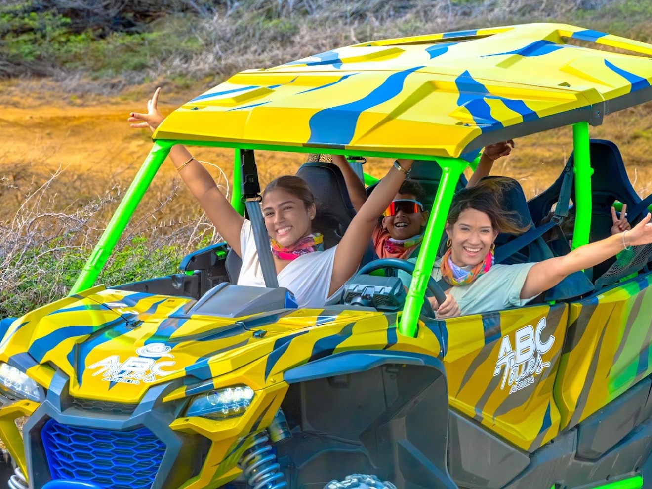 Group of people joyfully riding in a colorful off-road vehicle.