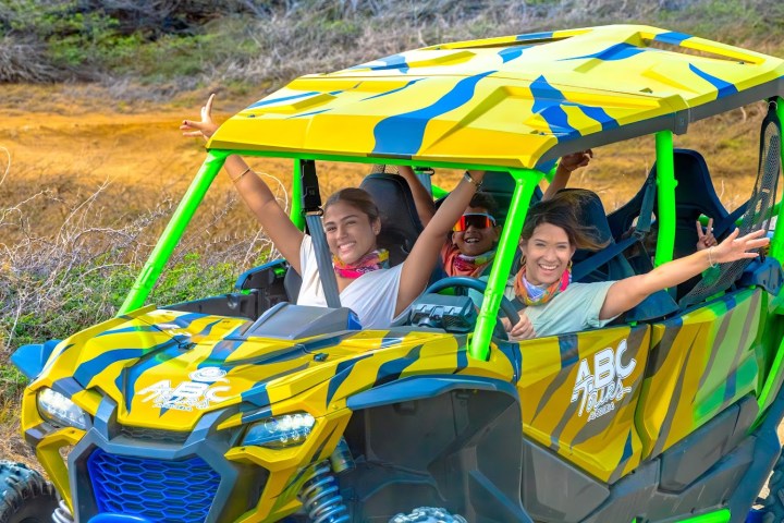 Group of people joyfully riding in a colorful off-road vehicle.